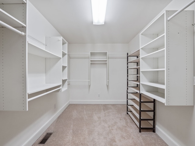 walk in closet with visible vents and light colored carpet