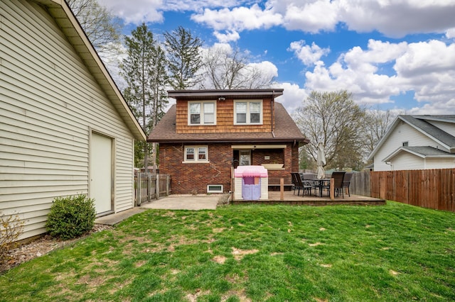back of property featuring a lawn, brick siding, a patio area, and a fenced backyard