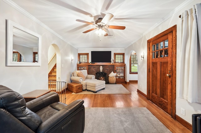 living room featuring arched walkways, wood finished floors, and ceiling fan