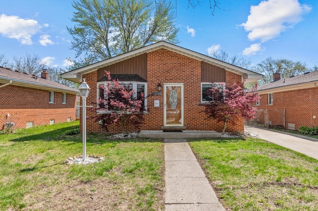 bungalow-style home featuring brick siding and a front yard