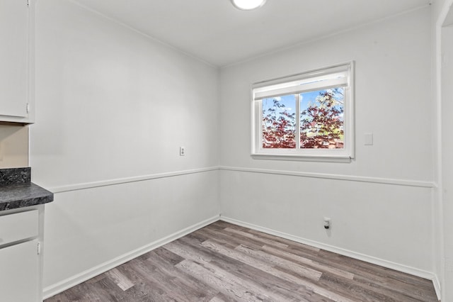 unfurnished dining area with baseboards and wood finished floors