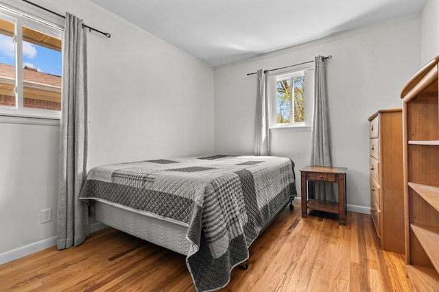 bedroom featuring baseboards and wood finished floors