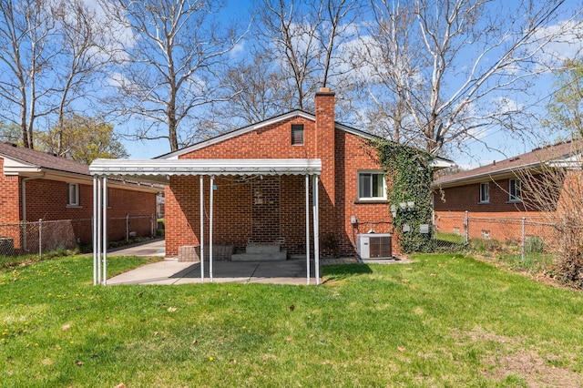 back of property featuring a lawn, a fenced backyard, a patio area, and a chimney
