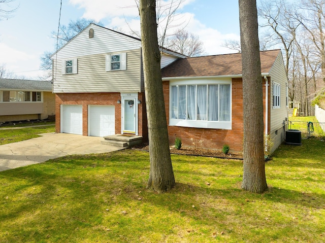 135 California Ave, Muskegon, MI 49445 - tri-level home featuring a front lawn, central AC unit, driveway, brick siding, and a garage