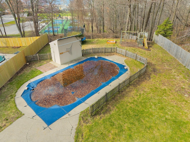 135 California Ave, Muskegon, MI 49445 - view of pool with a playground, a fenced backyard, an outdoor structure, a yard, and a storage unit