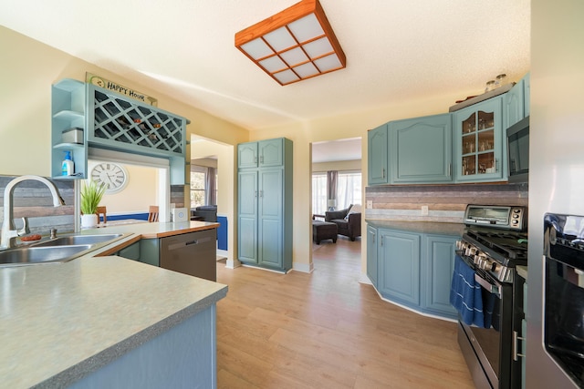 135 California Ave, Muskegon, MI 49445 - kitchen featuring tasteful backsplash, a sink, glass insert cabinets, stainless steel appliances, and light wood-style flooring