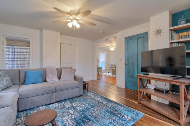 living room featuring wood-type flooring and ceiling fan