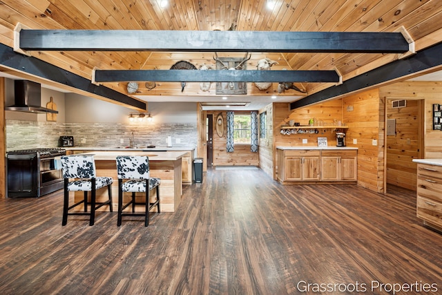 2697 N 176th Ave, Walkerville, MI 49459 - kitchen with wall chimney range hood, range with two ovens, dark wood finished floors, light countertops, and wood walls