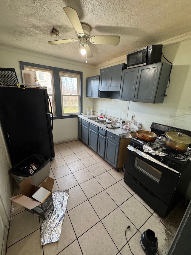kitchen with light tile patterned floors, crown molding, black appliances, a textured ceiling, and ceiling fan