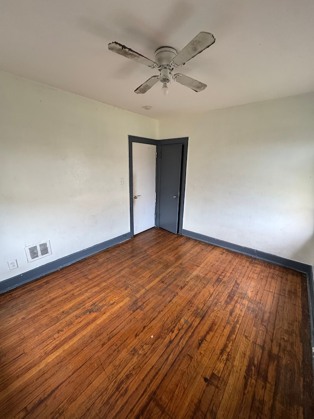 unfurnished room with wood-type flooring, visible vents, baseboards, and ceiling fan