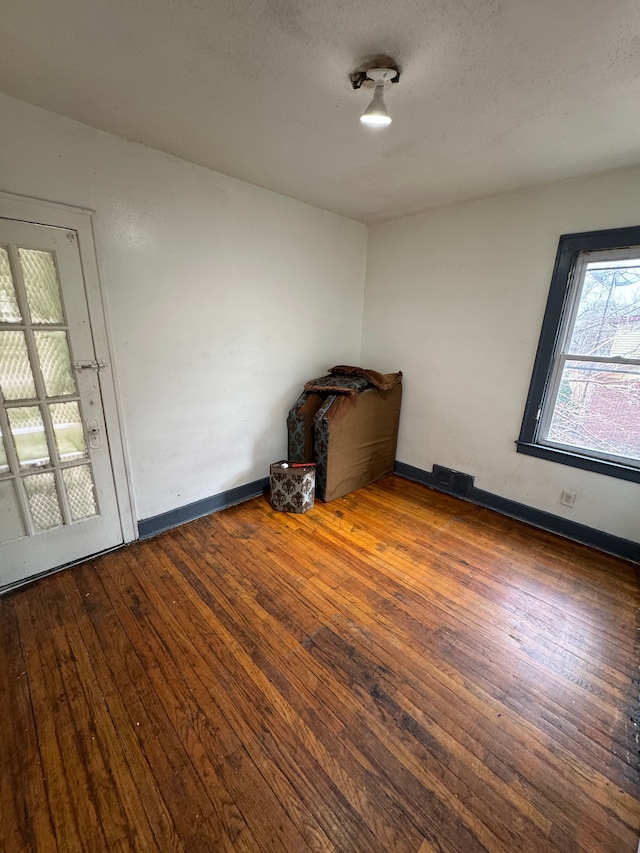 empty room featuring wood-type flooring and baseboards