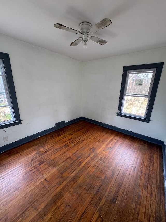 spare room featuring ceiling fan, baseboards, hardwood / wood-style floors, and visible vents