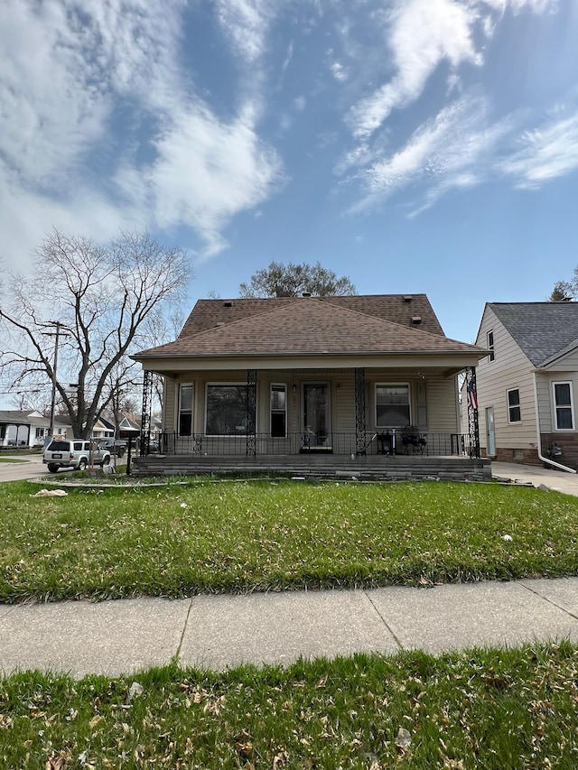 2011 Goddard Rd, Lincoln Park, MI 48146 - bungalow-style home featuring roof with shingles, a porch, and a front yard