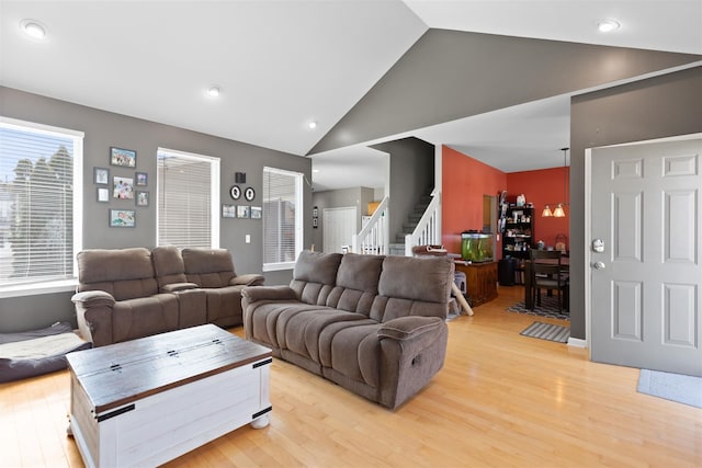 living room featuring light wood-style flooring, recessed lighting, stairway, and high vaulted ceiling