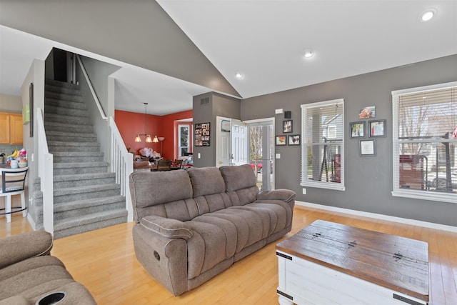 living area featuring recessed lighting, stairway, lofted ceiling, an inviting chandelier, and light wood-type flooring