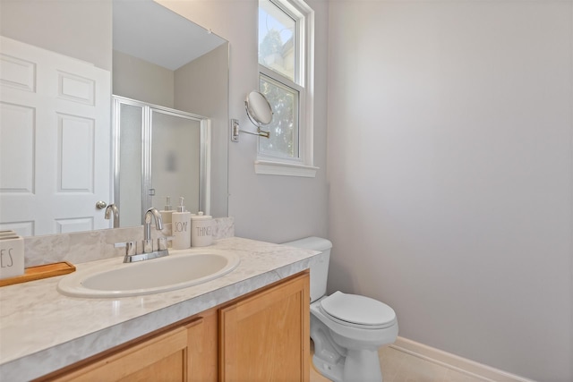 bathroom with vanity, toilet, a stall shower, and plenty of natural light