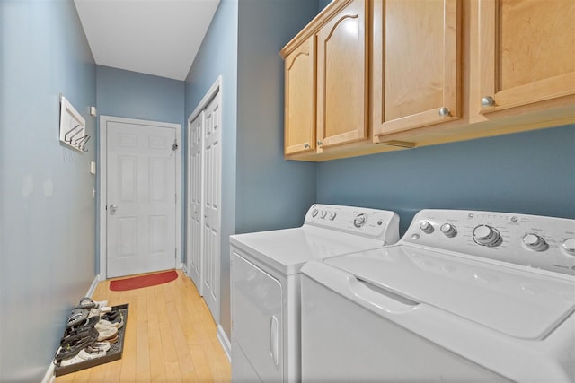 laundry room with cabinet space, light wood-type flooring, baseboards, and washer and dryer
