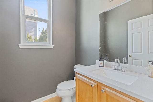 bathroom with baseboards, toilet, and vanity