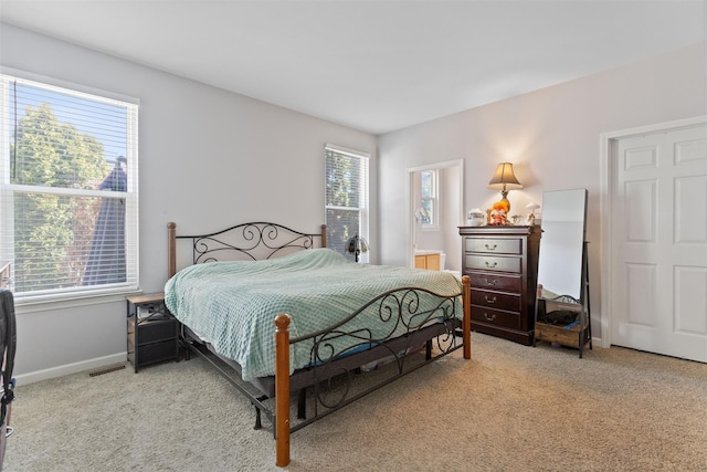 bedroom featuring light colored carpet, multiple windows, and visible vents