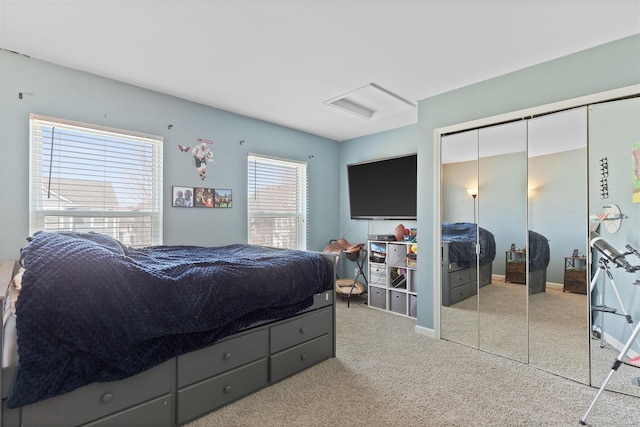 bedroom featuring attic access, baseboards, a closet, and light colored carpet