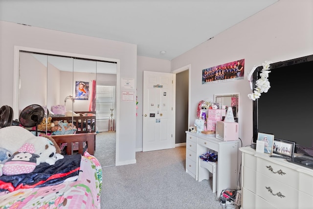 bedroom with light carpet, baseboards, and a closet