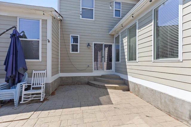 view of exterior entry with a patio area