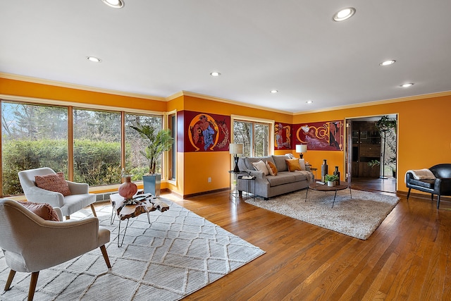 living area featuring baseboards, crown molding, wood finished floors, and recessed lighting