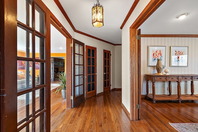 hall featuring french doors, baseboards, ornamental molding, and wood-type flooring