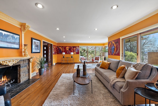 living area with recessed lighting, a fireplace, and crown molding