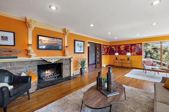 living room featuring wood finished floors, visible vents, recessed lighting, and crown molding