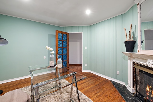 office with baseboards, wood finished floors, and a fireplace