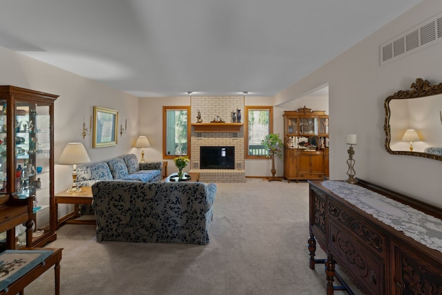 living area with visible vents, a brick fireplace, and carpet floors