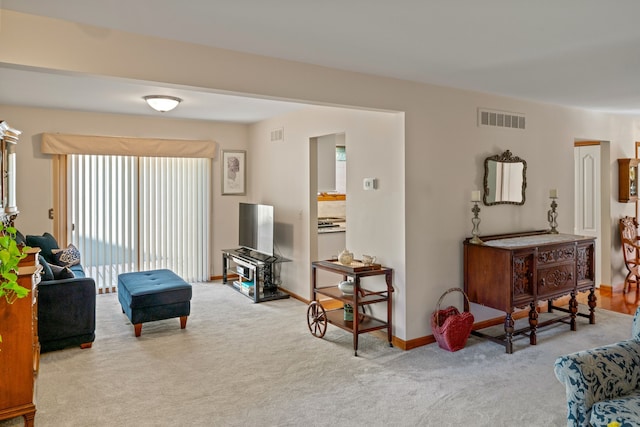 living room featuring visible vents, carpet, and baseboards
