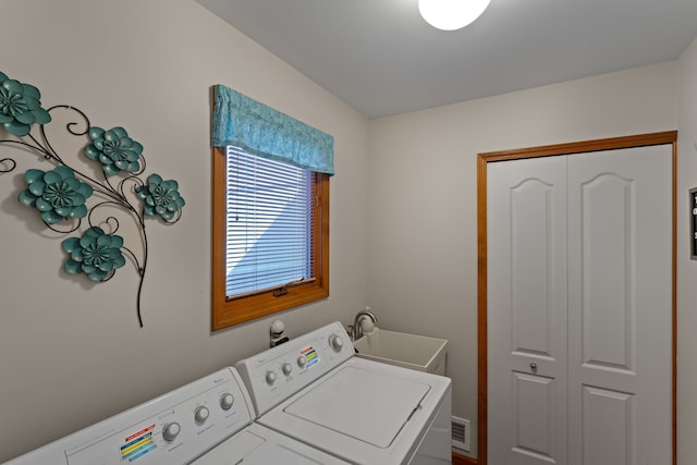 laundry area with a sink, visible vents, laundry area, and washer and clothes dryer