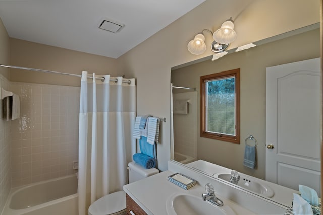 bathroom featuring vanity, shower / bath combo, toilet, and visible vents