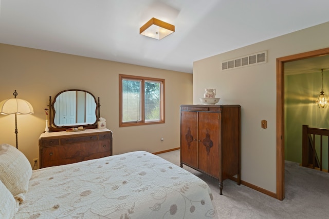 bedroom with baseboards, visible vents, and light carpet