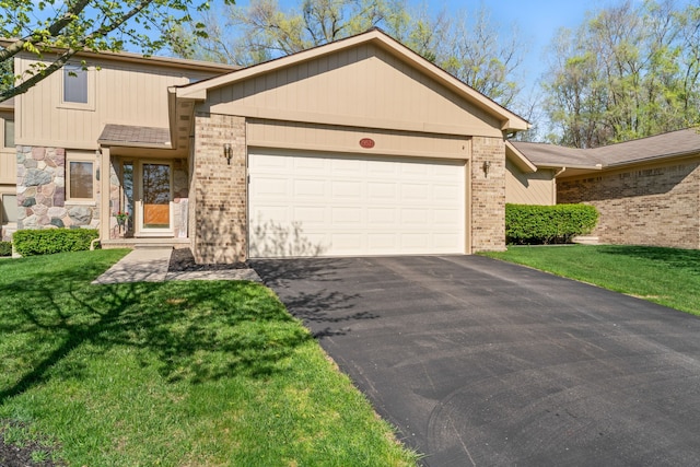 view of front facade with a garage, a front yard, driveway, and brick siding