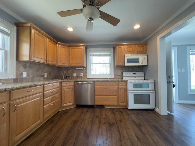 kitchen with white appliances, dark wood-type flooring, a sink, healthy amount of natural light, and ornamental molding