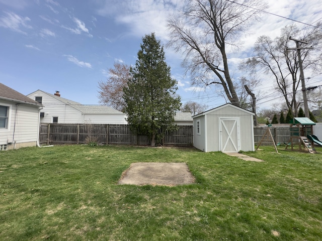 view of yard featuring a storage shed, a playground, and an outdoor structure