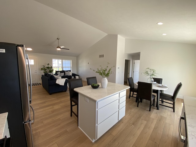9150 Cottage Xing Unit 23, Richland, MI 49083 - kitchen with freestanding refrigerator, vaulted ceiling, light wood-style floors, white cabinetry, and a kitchen island
