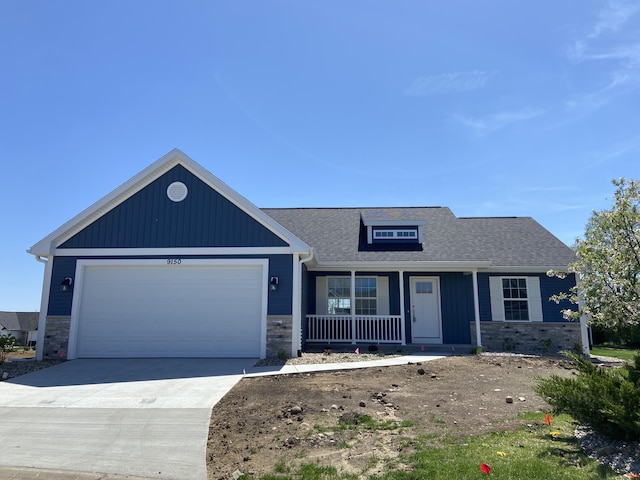 9150 Cottage Xing Unit 23, Richland, MI 49083 - view of front of property with stone siding, covered porch, an attached garage, driveway, and a shingled roof