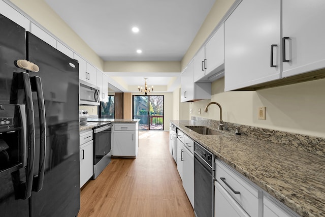 kitchen featuring white cabinets, a notable chandelier, a sink, and black appliances