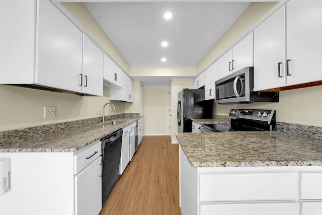 kitchen with recessed lighting, white cabinets, a sink, light wood-style floors, and black appliances