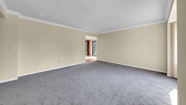 carpeted empty room with crown molding and baseboards