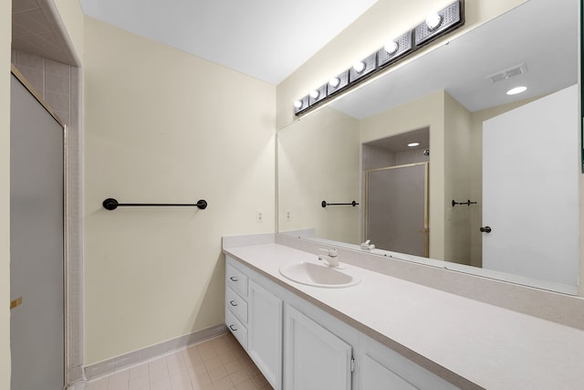 bathroom with a stall shower, visible vents, baseboards, tile patterned flooring, and vanity