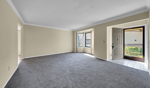 unfurnished room with baseboards, carpet flooring, tile patterned flooring, and crown molding