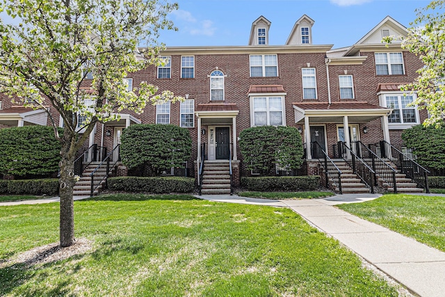view of property featuring brick siding and a front yard