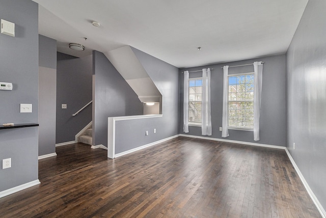 bonus room featuring baseboards, stairway, and wood finished floors