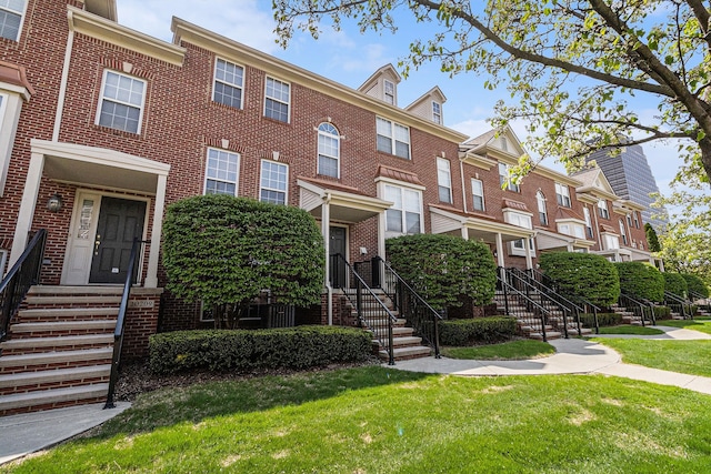 view of property featuring brick siding and a front yard