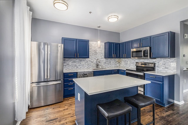 kitchen featuring appliances with stainless steel finishes, blue cabinetry, and a sink